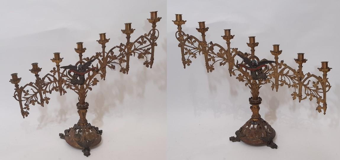 A pair of continental ecclesiastical gothic seven light candlesticks, of graduating form, with