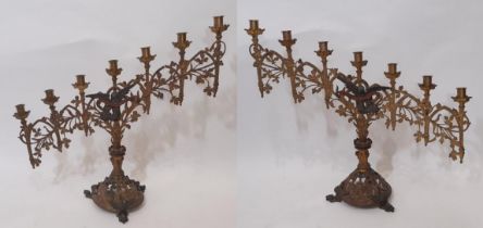 A pair of continental ecclesiastical gothic seven light candlesticks, of graduating form, with