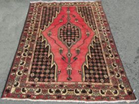 A Persian Hamadan carpet with washed red ground, fine woven pile with a central medallion, 195cm x