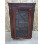 A Georgian mahogany hanging corner cabinet enclosed by a rectangular astragal glazed panelled door