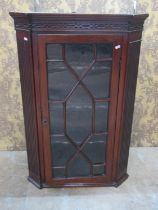 A Georgian mahogany hanging corner cabinet enclosed by a rectangular astragal glazed panelled door