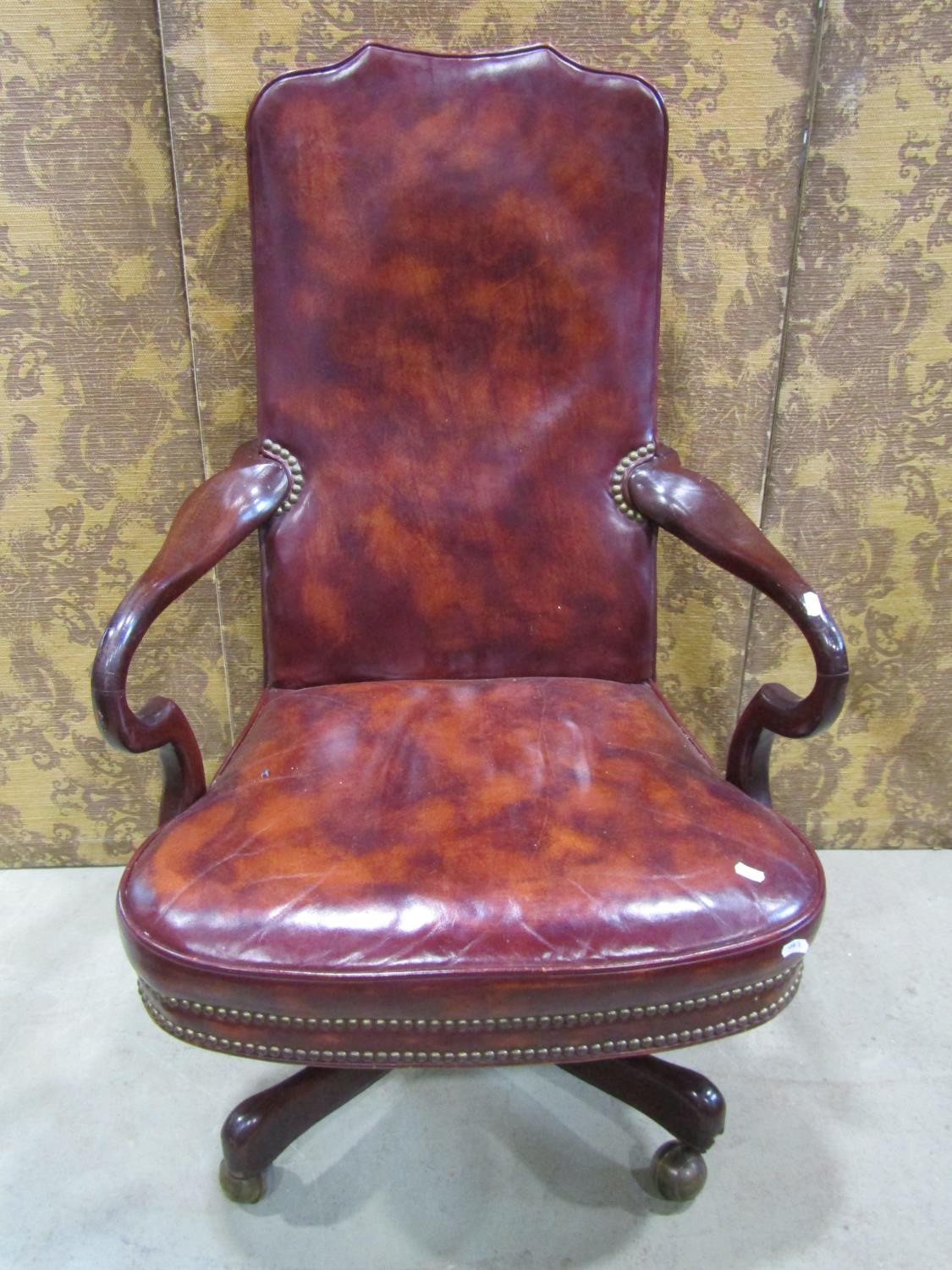 A library chair in the Georgian style with chestnut coloured leather upholstery within a mahogany
