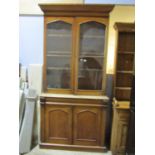 A Victorian mahogany library bookcase, the lower section enclosed by a pair of arched panelled doors