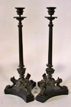 A pair of 19th century bronze candlesticks, in the form of tapering fluted columns raised on