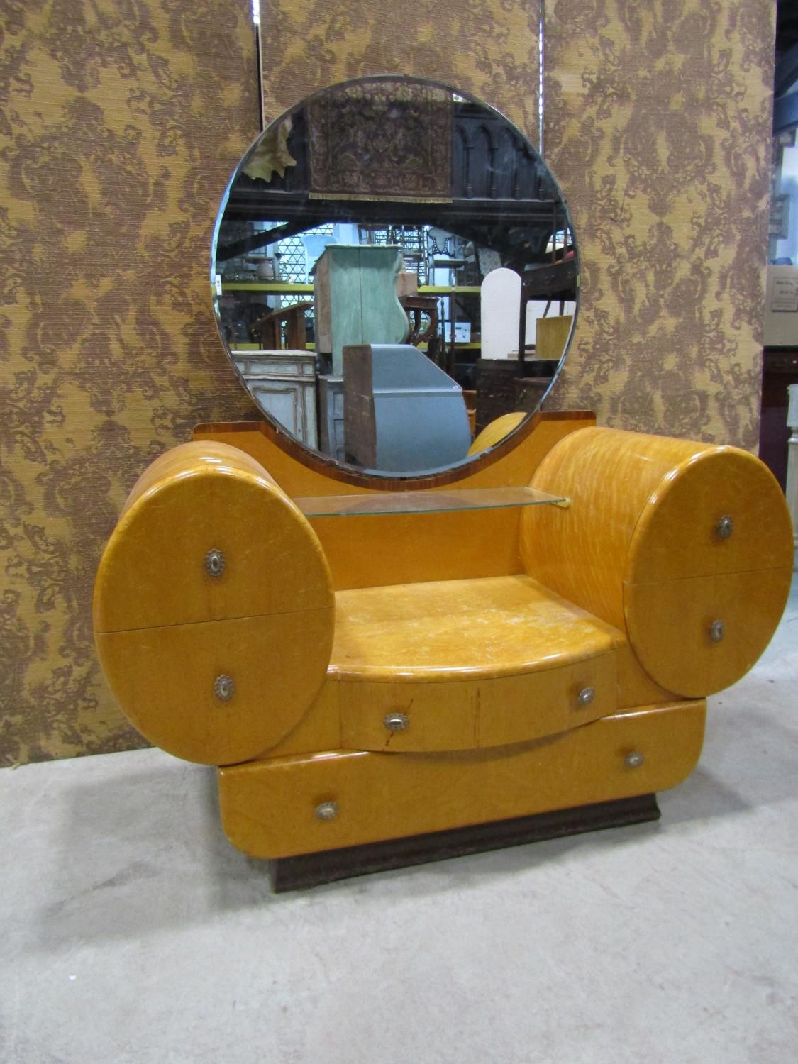 A high Art Deco dressing table, the circular mirror plate within an arrangement of six drawers in