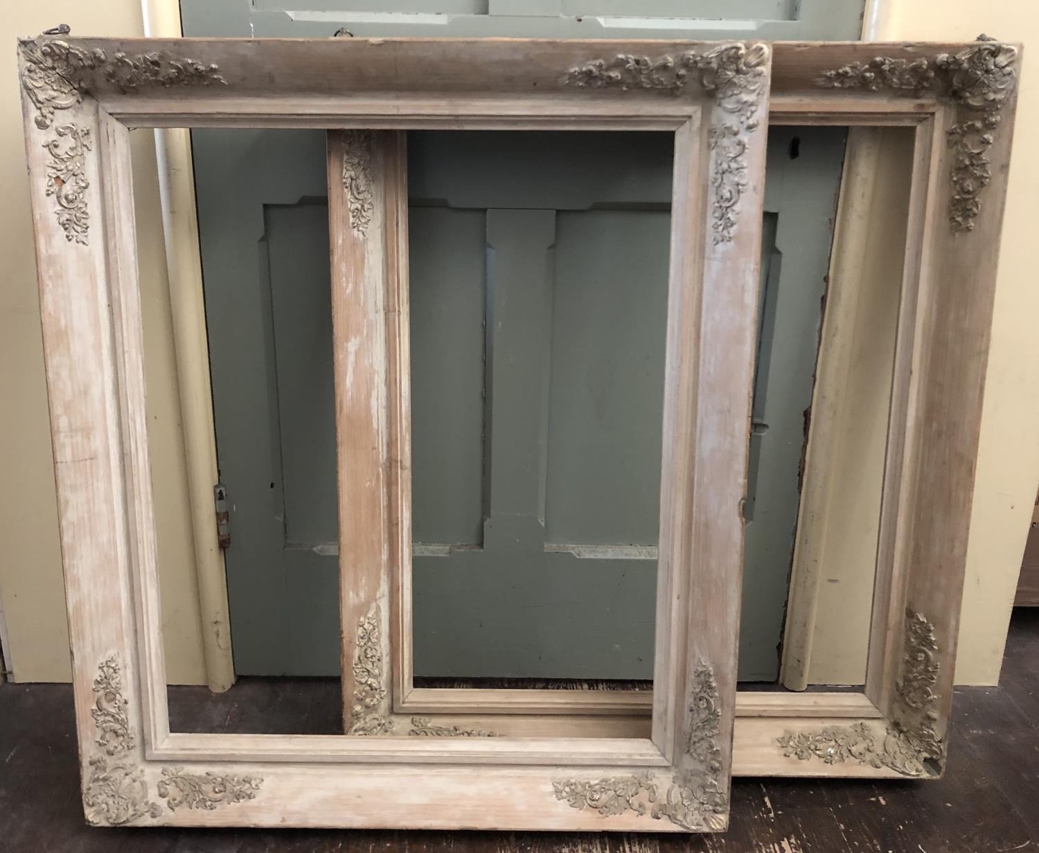 A pair of 19th century wooden frames with washed finish and moulded floral decorations to each