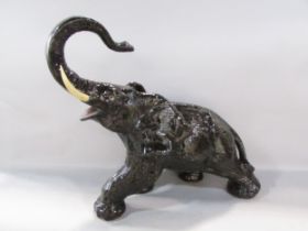 A plaster rampaging elephant in painted black glazed finish 40cm high