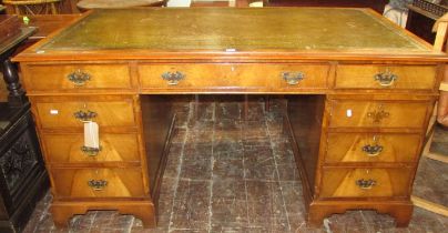 A good quality reproduction Georgian style twin pedestal desk in walnut, with mid-green coloured