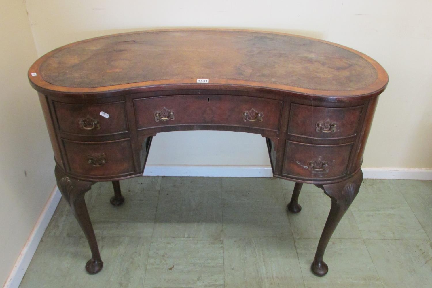 A walnut framed kneehole kidney shaped writing desk fitted with five drawers on pad feet with