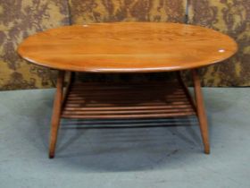 An Ercol occasional table of oval form, on turned supports with under gallery, with well figured elm