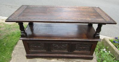 a late 19th century oak monks bench with geometric carved panels on turned supports, with rising/