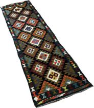 A Maimana kilim runner with staggered stepped diamonds on a dark field, 292 x76cm approximately