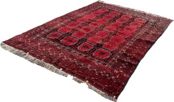 An Afghan carpet with a red and black panelled design, 260 x 200cm approximately