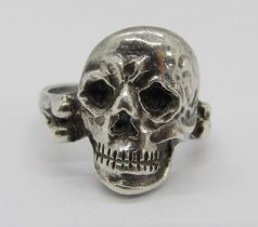 An unusual antique French silver ring in the form of a human skull, the shank forming a bone,