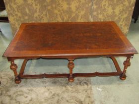 A Queen Ann style walnut and figured walnut low occasional table raised on six turned supports