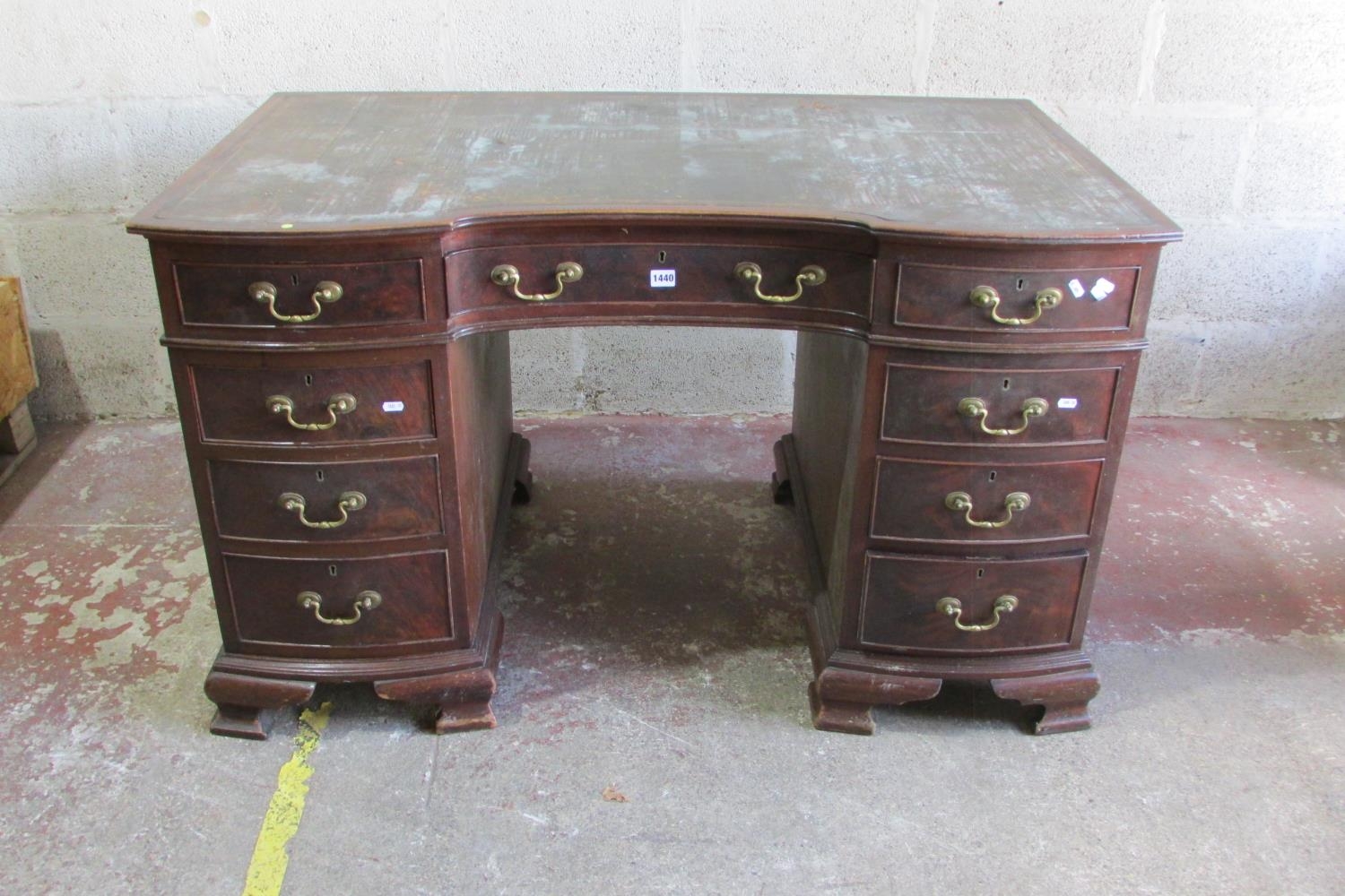 An Edwardian mahogany pedestal writing desk with inset leather top, the shaped outline incorporating