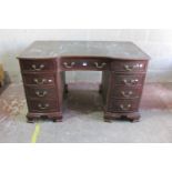 An Edwardian mahogany pedestal writing desk with inset leather top, the shaped outline incorporating