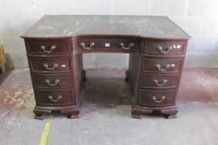 An Edwardian mahogany pedestal writing desk with inset leather top, the shaped outline incorporating