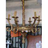 A carved pine and gilded five branch chandelier with scrolled arms and further leaf moulded