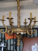 A carved pine and gilded five branch chandelier with scrolled arms and further leaf moulded