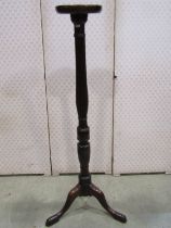 A mahogany torchere with reeded column on tripod legs