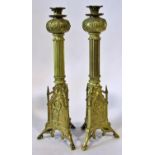 A pair of 19th century Puginesque brass candlesticks, with flared pomegranate shaped cradles, over