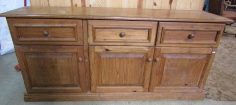 A large rustic pine dresser base enclosed by three doors and three drawers, 170cm long x 48cm deep x
