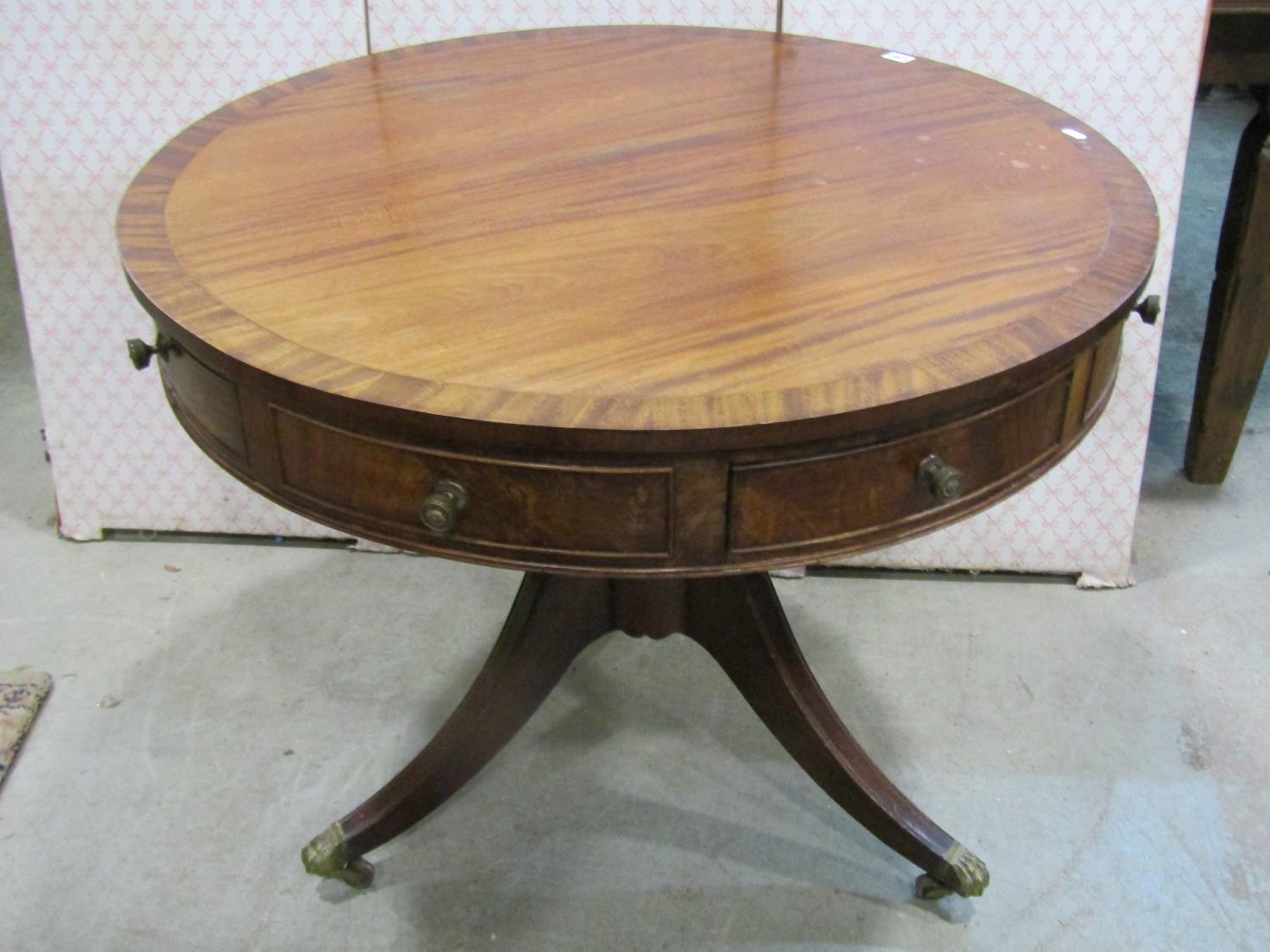 A Regency style drum table in mahogany, with alternating real and dummy drawers on turned support