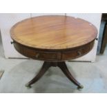 A Regency style drum table in mahogany, with alternating real and dummy drawers on turned support