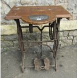 A vintage cast iron treadle sewing machine base with scumbled wooden top