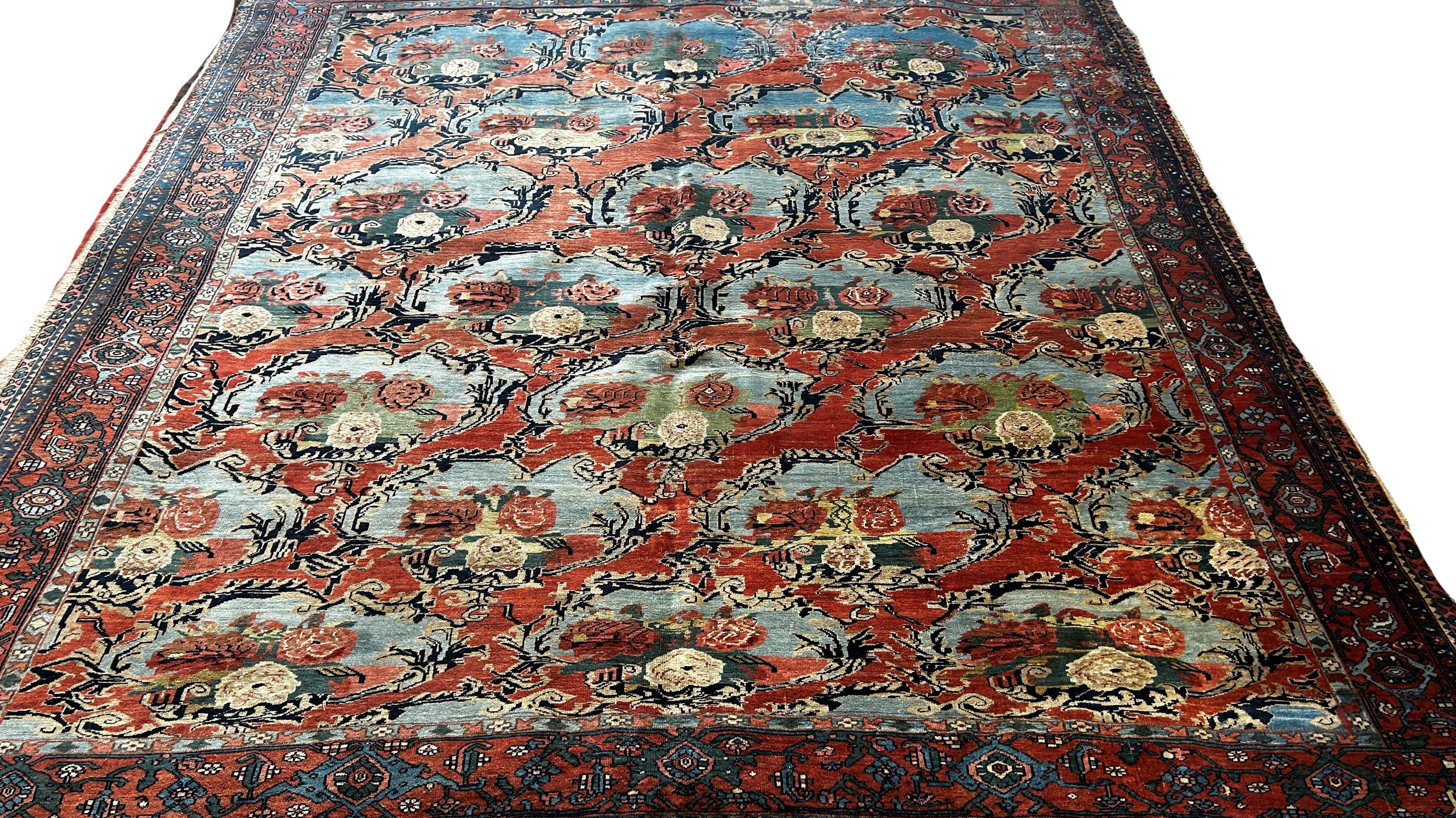 An Old Persian carpet with a repeating floral pattern on a pink ground, one corner badly worn with - Image 3 of 3