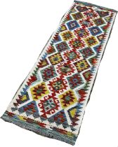 A Chobi kilim runner with alternating rows of diamonds and irregular connected medallions 196 x 62cm