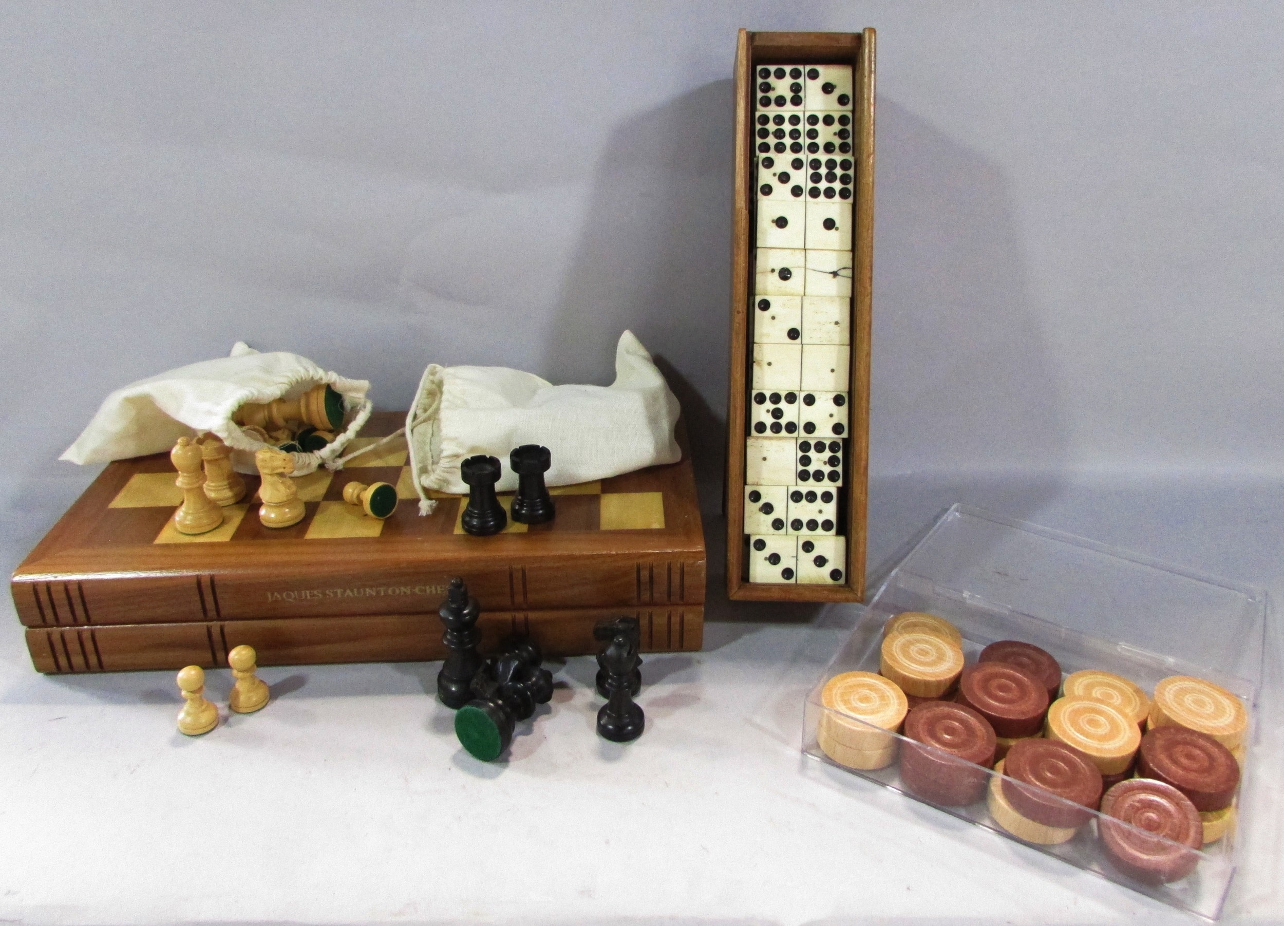An Antique Nine Dot Domino set in a wooden case, only 53 tiles, a set of wooden draughts counters,