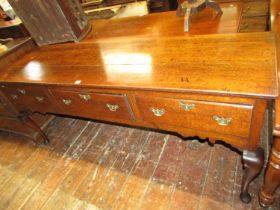 A Georgian oak dresser base fitted with three frieze drawers, shaped apron and shaped forelegs,