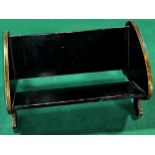 A black lacquered and painted book trough with hand painted Man of War sailing ships to the ends,