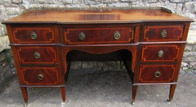 An Edwardian desk breakfront writing desk fitted with seven drawers with satin banded detail,
