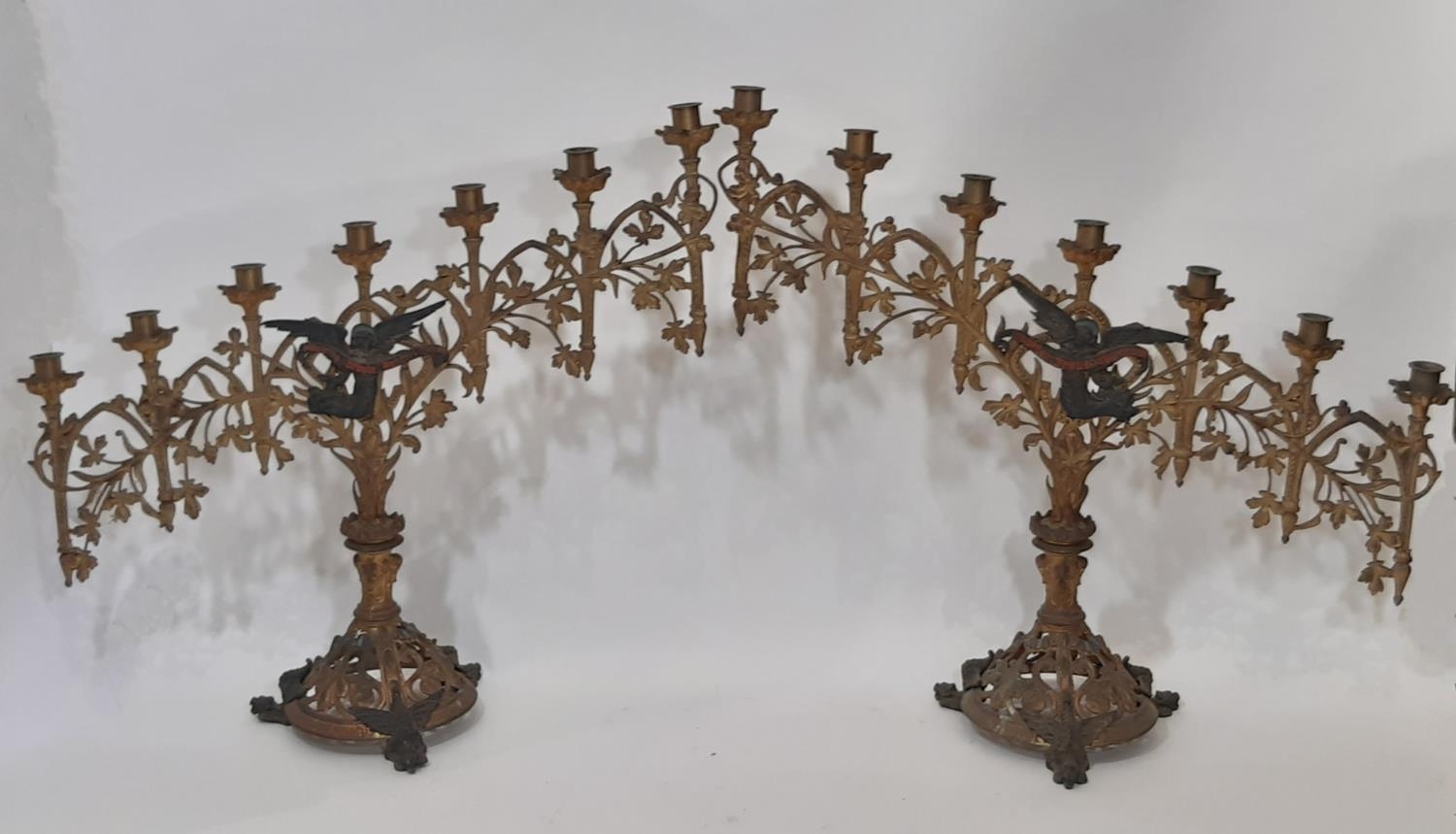 A pair of 19th century continental ecclesiastical gothic seven light candelabra, of graduating