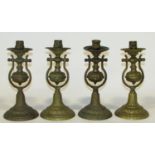 A set of four 19th century wall-hanging brass cradle candle sconces, each with weighted bases set