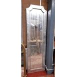 A tall 20th century wall mirror of canted rectangular form in the art deco style, 215cm high x