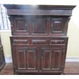 An 18th century oak Dudarn, the lowers section enclosed by two panelled doors and three frieze