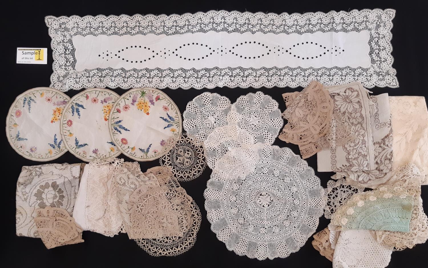 A collection of vintage table linen including colourful embroidered small mats, Maltese lace mats,