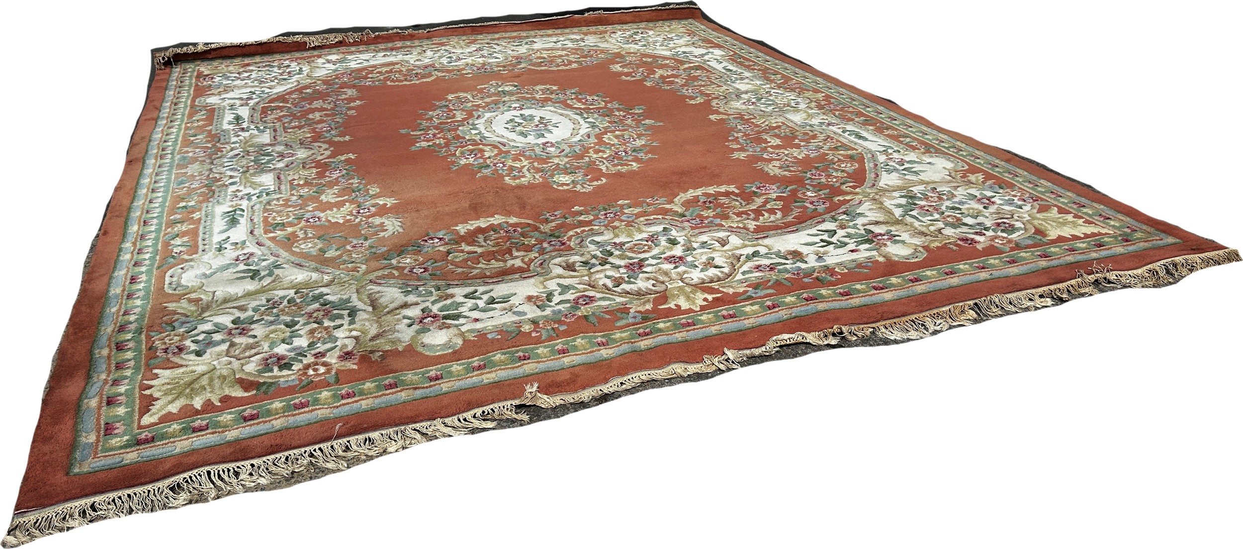 A large country house Aubusson style thick wool pile carpet with a floral medallion on an apricot