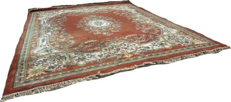 A large country house Aubusson style thick wool pile carpet with a floral medallion on an apricot