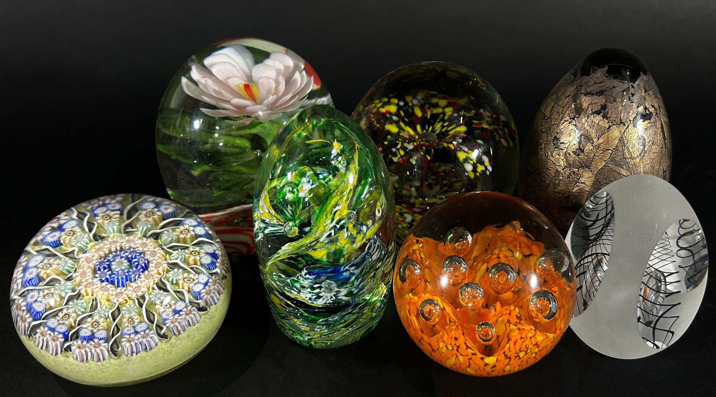 A collection of 15, 20th century, glass paperweights of varying designs flowers, bubbles and swirls,
