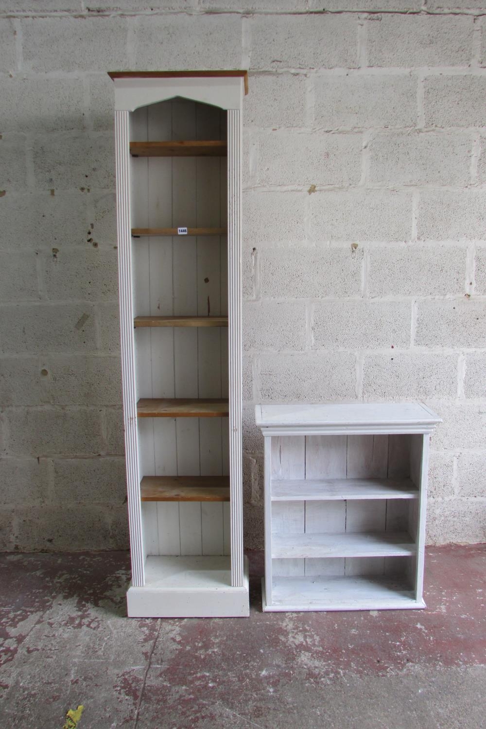 A tall narrow upright bookcase enclosing adjustable shelves within a painted and reeded framework