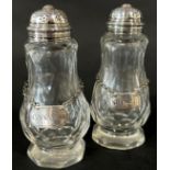 A pair of cut glass spice dispensers with pierced cap, with two silver ladles, cinnamon and