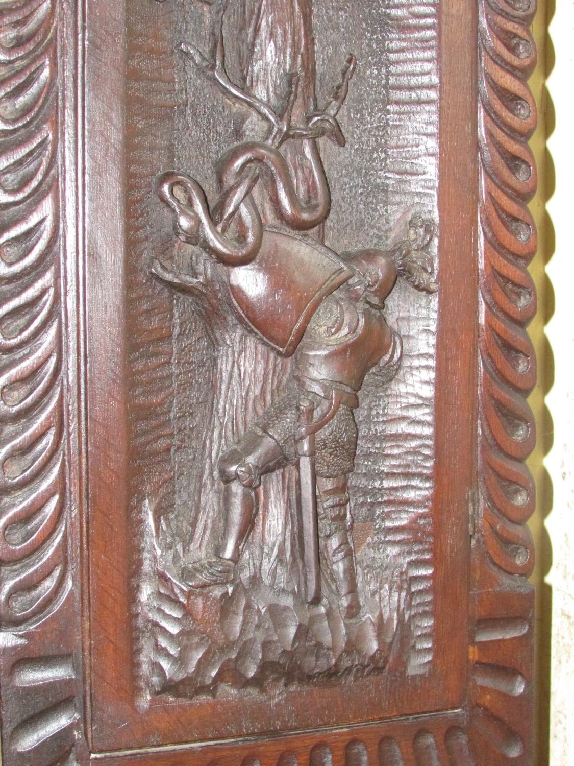 A 19th century oak longcase clock with heavy estate carving, the trunk detailing a knight fighting - Image 15 of 17