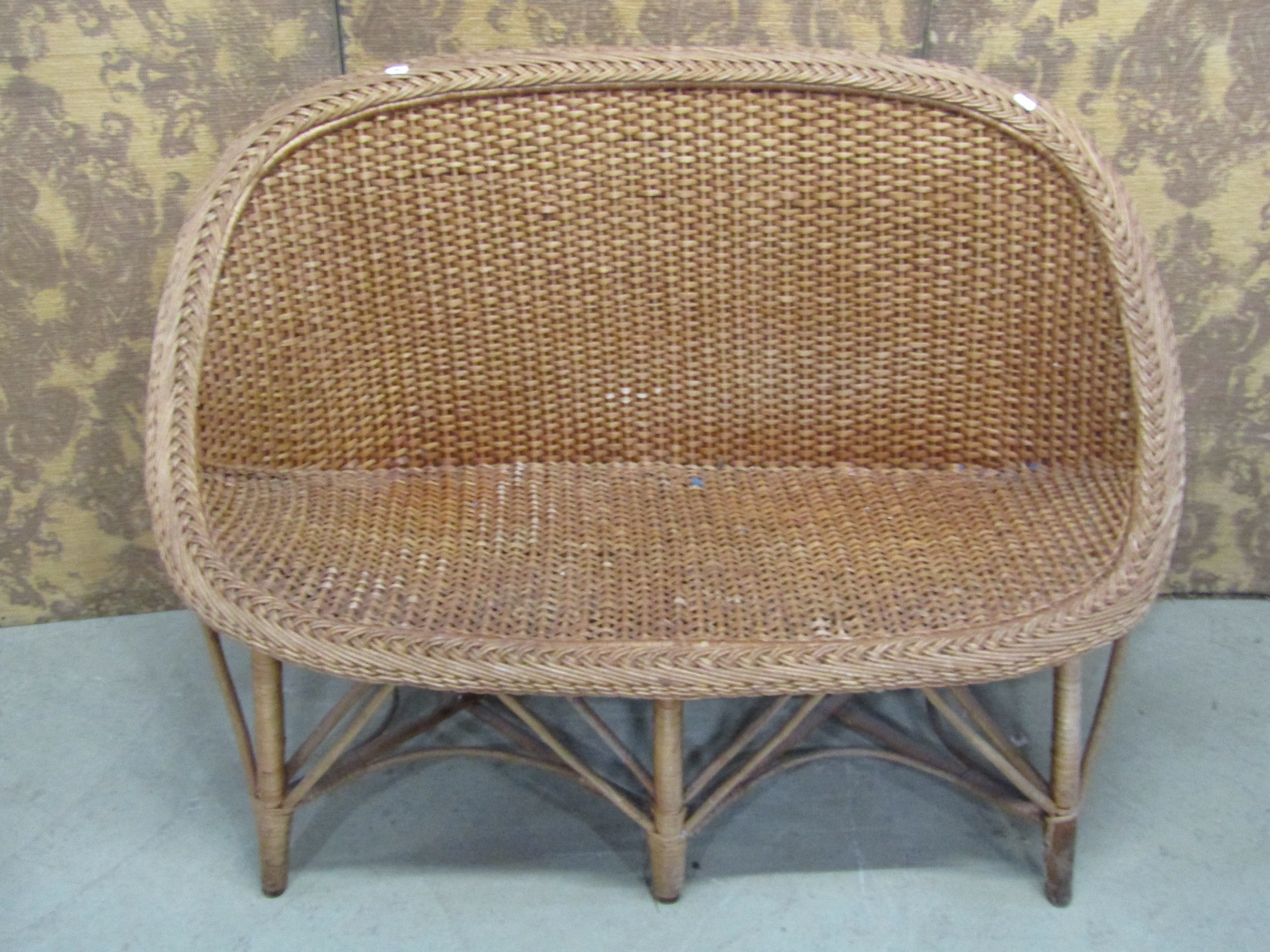 A vintage wicker two seat sofa, a mid century wicker plate glass occasional table of circular form