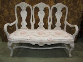 A dry-scraped settle in the Queen Anne style with triple vase shaped splats, shaped arms and seat,