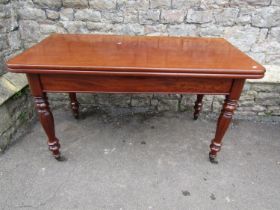 A 19th century mahogany mahogany fold over top dining table raised on four octagonal supports and